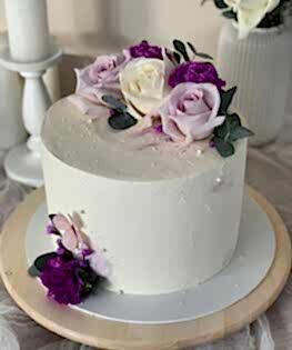 Белый торт с живыми цветами и монпарелем