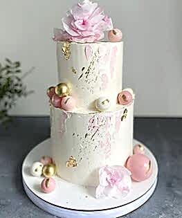 Свадебный торт в два яруса в розовом цвете с шоколадными шарами и сахарными цветами