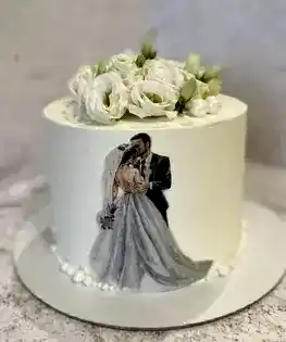 Белый свадебный торт с живыми цветами, топппером жениха и невесты