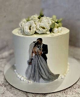 Белый свадебный торт с живыми цветами, топппером жениха и невесты