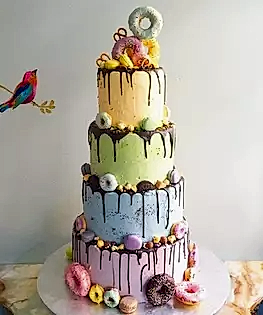 Яркий свадебный торт в четыре яруса с пончиками