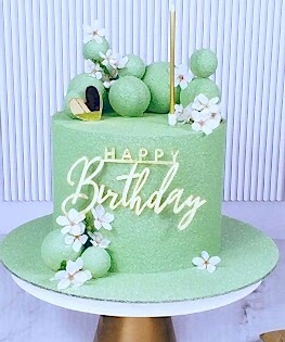 Торт нежно-зеленый с сахарными цветами, шоколадными шарами и топпером