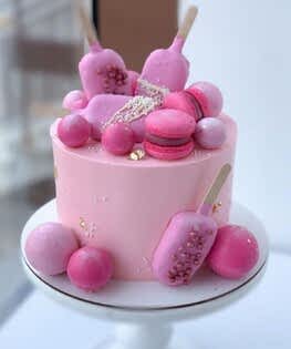 Торт розовый с шарами, эскимо и макарунами