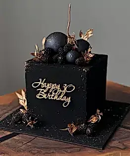 Торт черный с шоколадными шарами, ягодами и позолотой