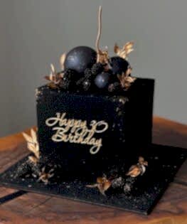 Торт черный с шоколадными шарами, ягодами и позолотой