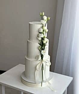 Свадебный современный торт с живыми цветами и лентой в три яруса